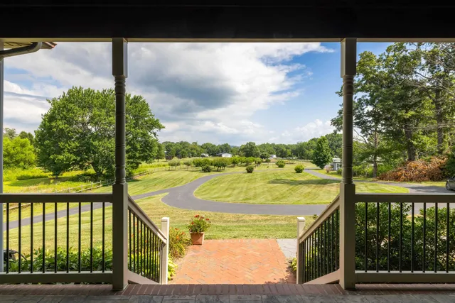 a living room with furniture kitchen view and a wooden floor