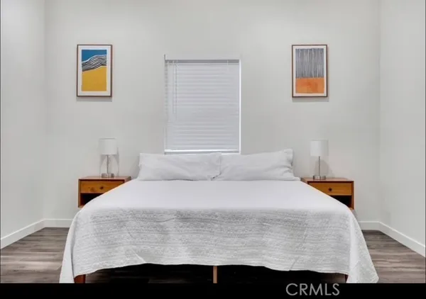 a bedroom with a bed and painting on the wall