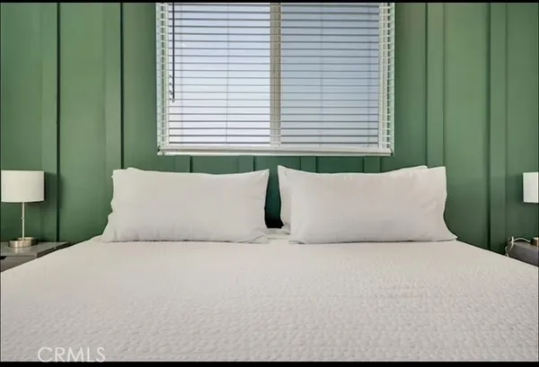 a bed sitting in a bedroom next to a window