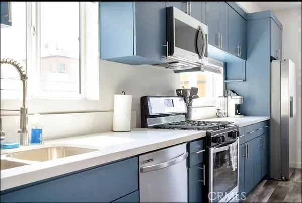 a kitchen with stainless steel appliances granite countertop a sink a stove and a microwave