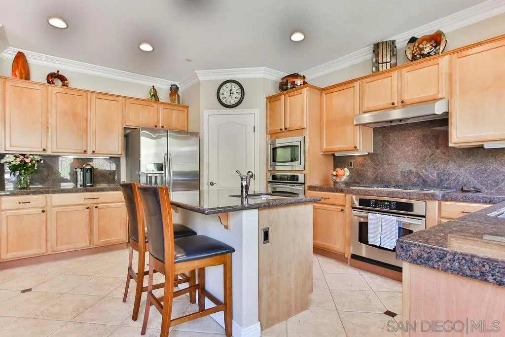 16237 Cayenne Ridge Road San Diego, CA 92127 - Photo 6 of 34 a kitchen with stainless steel appliances granite countertop a stove a sink and a refrigerator