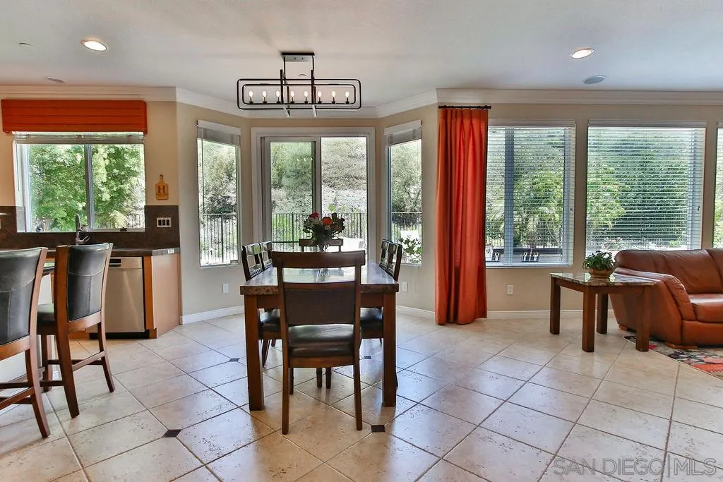 16237 Cayenne Ridge Road San Diego, CA 92127 - Photo 9 of 34 a view of a dining room with furniture large windows and chandelier