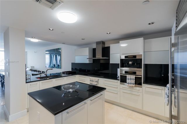 a kitchen with stainless steel appliances a refrigerator and a stove top oven