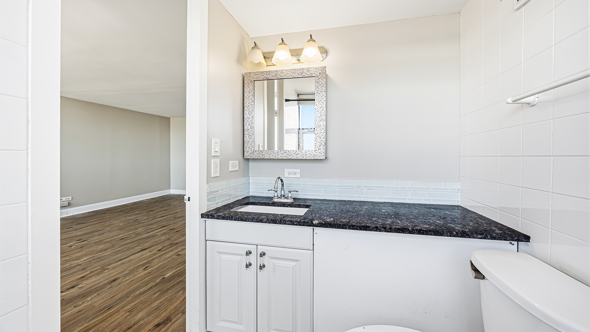 3110 North Sheridan Road, Unit 1807 Chicago, IL 60657 - Photo 16 of 21 a bathroom with a granite countertop sink and a mirror