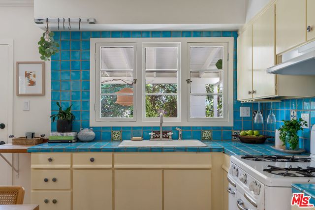 a kitchen with stainless steel appliances a sink a stove and a window