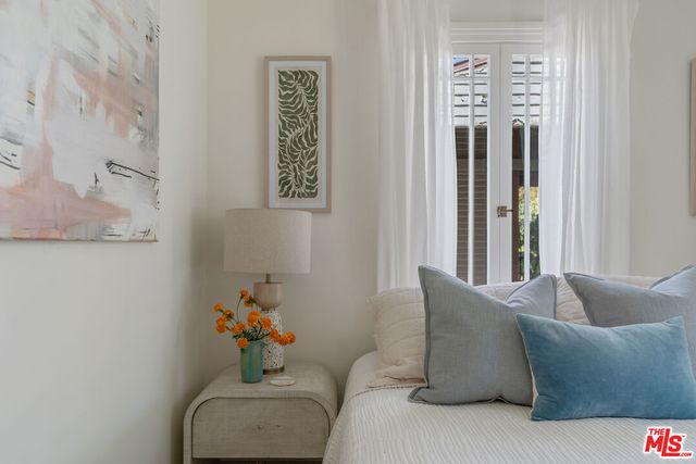 a bedroom with a bed and a potted plant