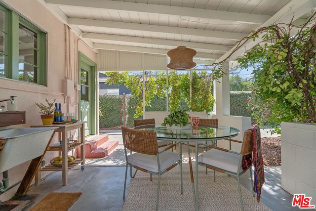 a view of a patio with table and chairs potted plants with large tree