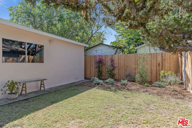 a view of backyard with outdoor seating and trees