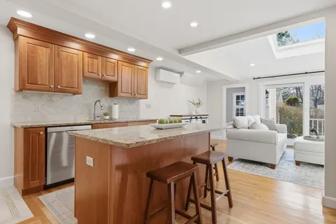 a kitchen with stainless steel appliances granite countertop a stove a sink dishwasher and a refrigerator with wooden floor