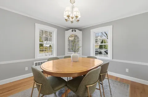 a dining room with furniture a rug and a chandelier