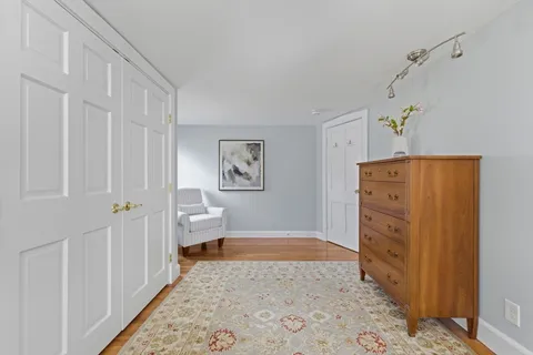 a view of a bedroom with wooden floor & hallway