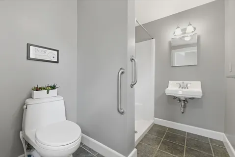 a bathroom with a toilet a sink and mirror