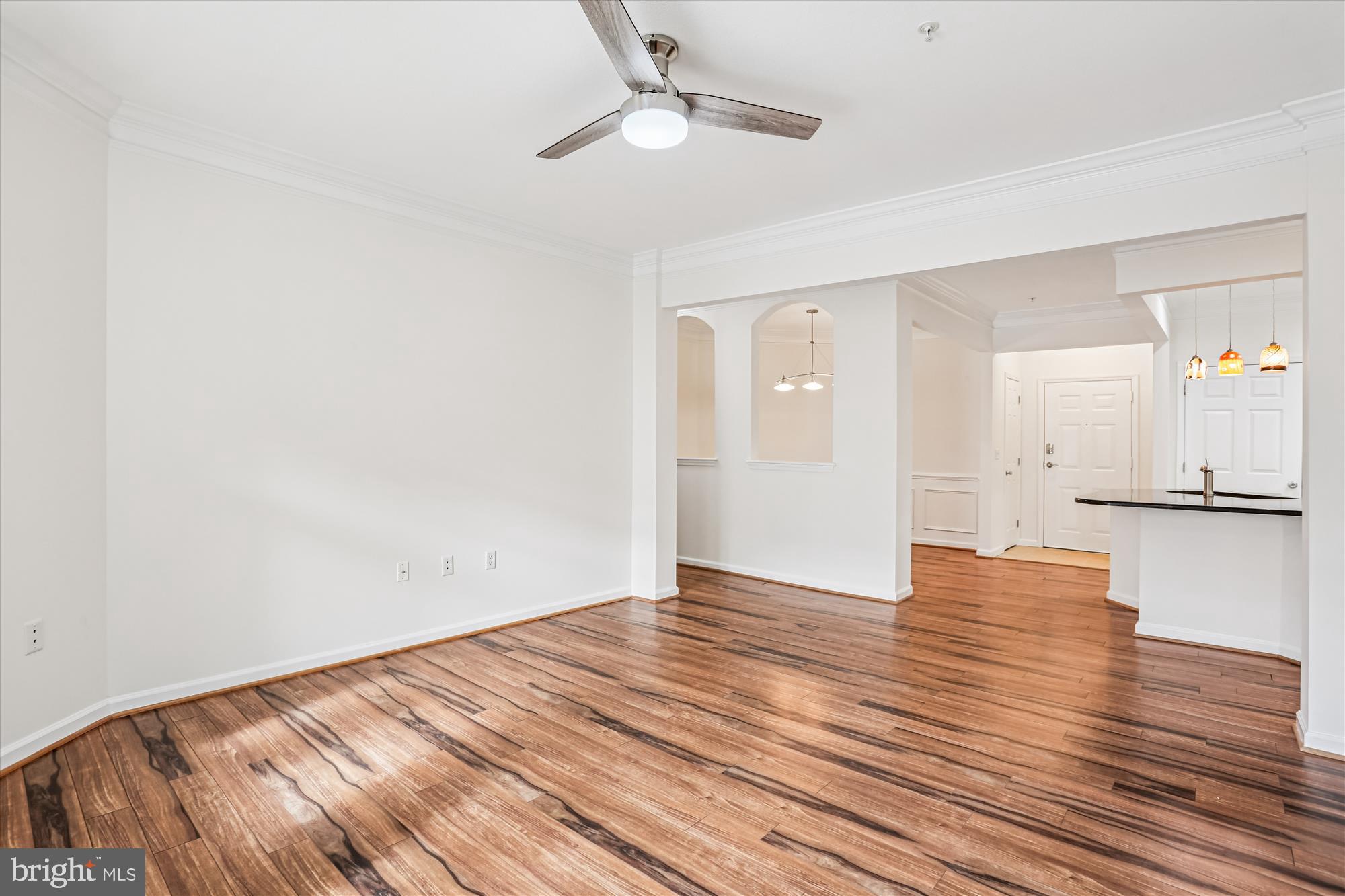 23 Arch Place, Unit 273 Gaithersburg, MD 20878 - Photo 6 of 103 an empty room with wooden floor a ceiling fan and kitchen view