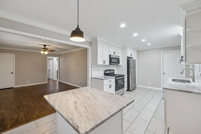 a kitchen with stainless steel appliances kitchen island sink refrigerator and cabinets
