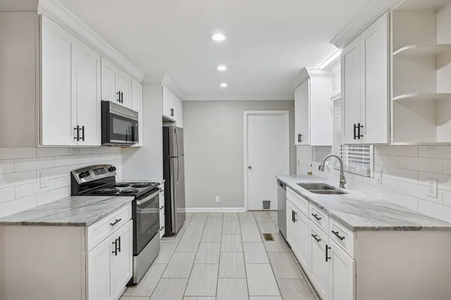 a kitchen with stainless steel appliances granite countertop a sink stove and refrigerator