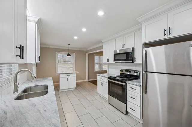 a kitchen with stainless steel appliances granite countertop a refrigerator stove microwave and sink