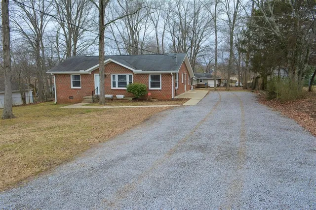 a front view of a house with a yard and trees