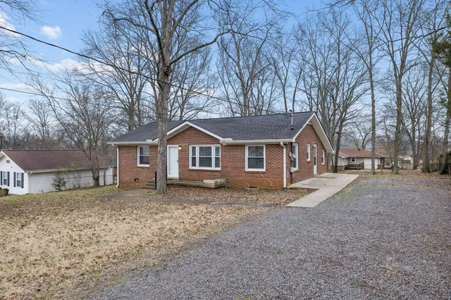 a front view of a house with yard and trees