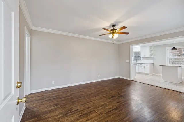 a view of a room with wooden floor and a ceiling fan