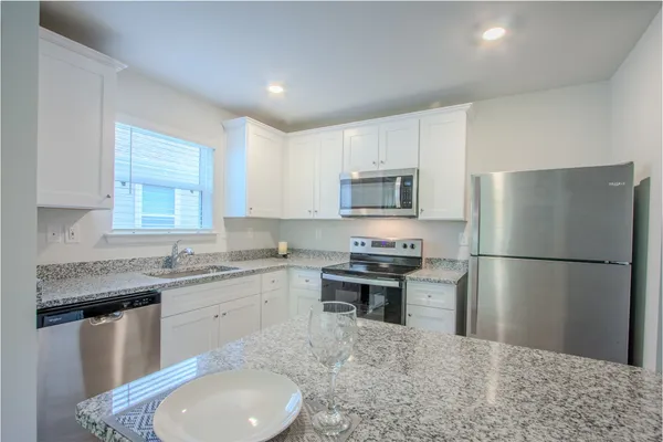 a kitchen with stainless steel appliances granite countertop a sink stove and refrigerator