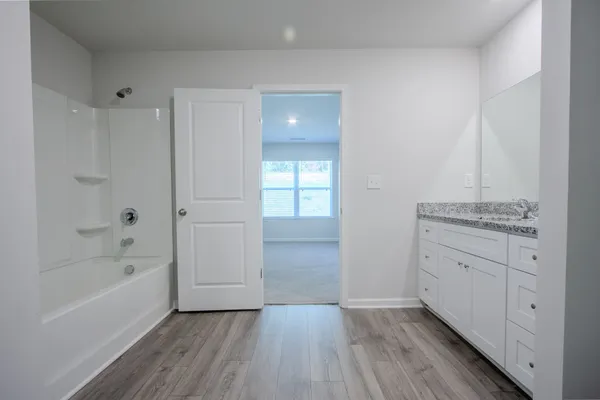 a bathroom with a granite countertop sink a toilet and bathtub