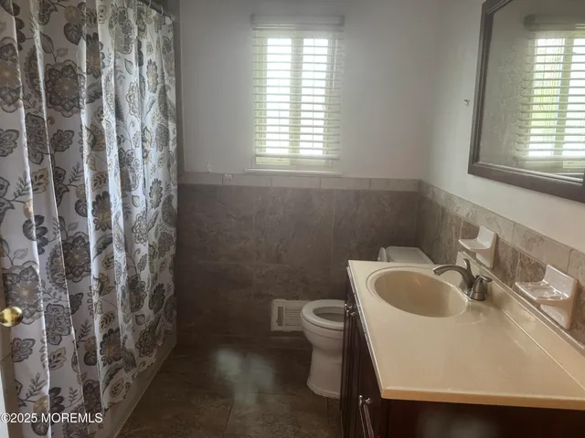 a bathroom with a sink toilet and window