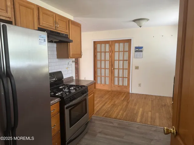 a kitchen with granite countertop a stove and a refrigerator