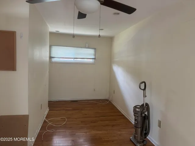 a view of a room with wooden floor and white walls