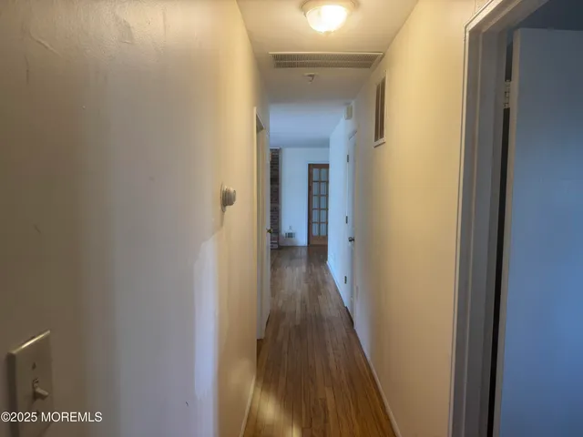 a view of a hallway with wooden floor