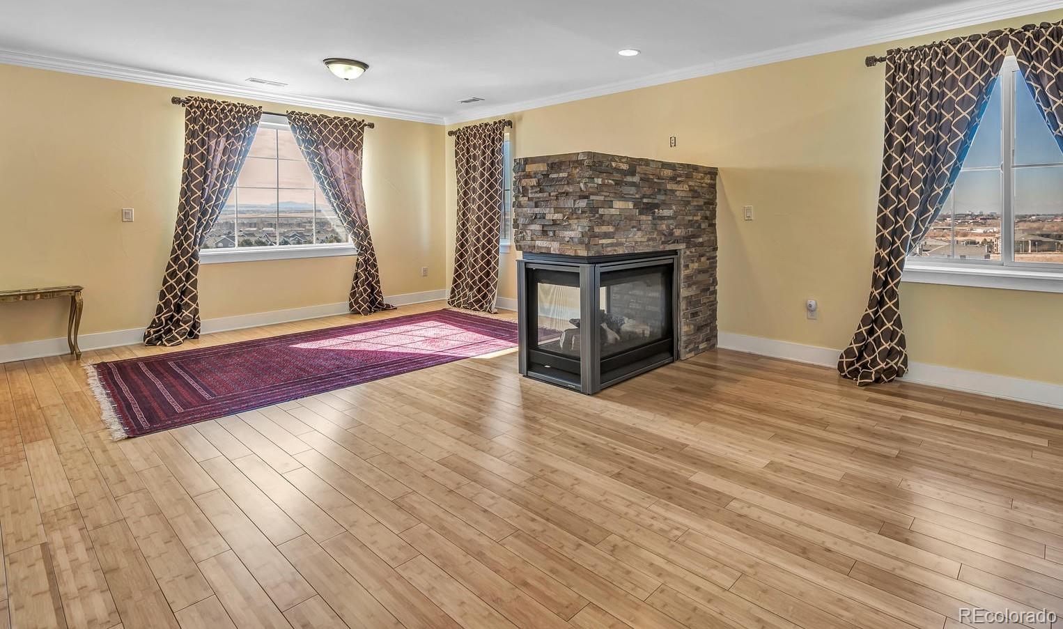 16520 East Easter Way Foxfield, CO 80016 - Photo 16 of 38 a spacious bedroom with a bed and a fireplace
