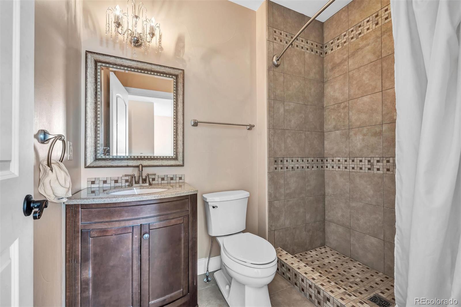 16520 East Easter Way Foxfield, CO 80016 - Photo 25 of 38 a bathroom with a sink a toilet and shower