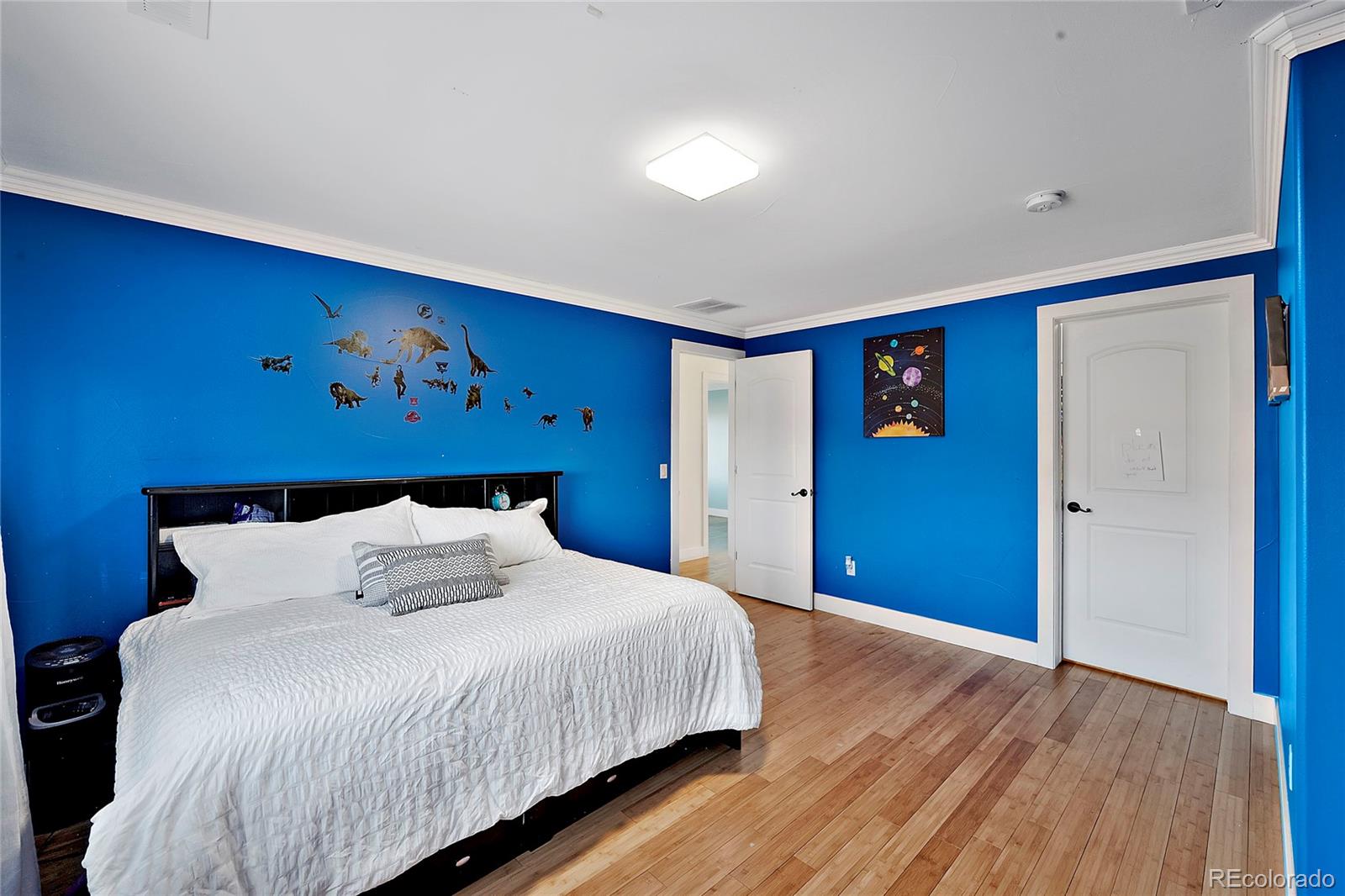 16520 East Easter Way Foxfield, CO 80016 - Photo 30 of 38 a bedroom with a large bed and wooden floor