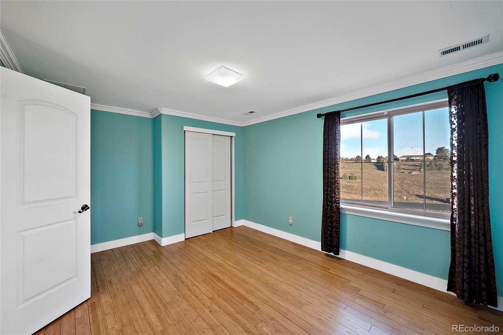 16520 East Easter Way Foxfield, CO 80016 - Photo 32 of 38 an empty room with wooden floor and windows
