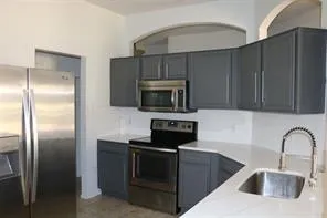 a kitchen with stainless steel appliances wooden cabinets a sink and a microwave
