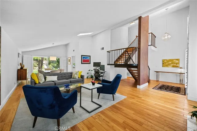 a living room with furniture kitchen view and a large window