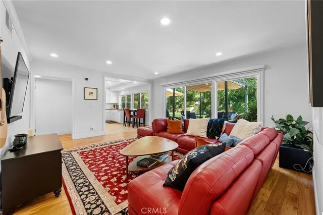 a view of a dining room and livingroom with furniture a rug a fireplace and a chandelier