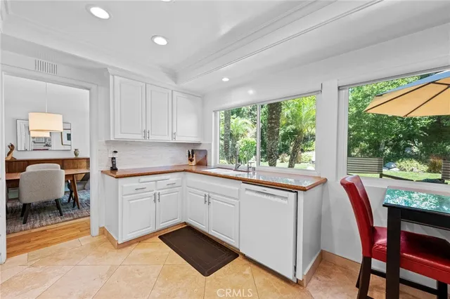 a kitchen with granite countertop white cabinets and a large window