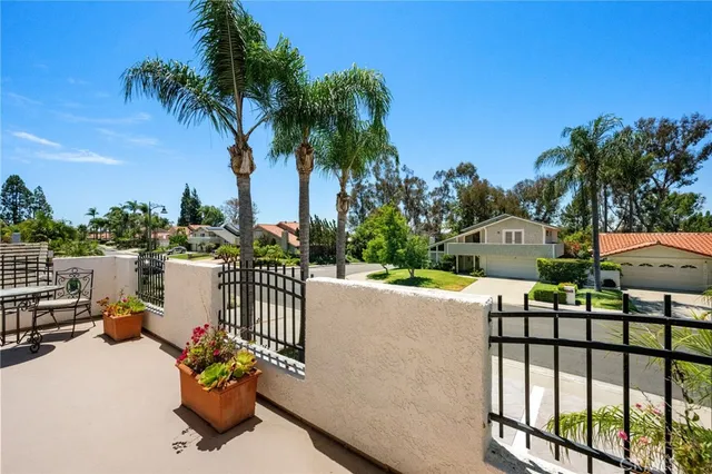 a view of a patio with a table and chairs under an umbrella with a small yard