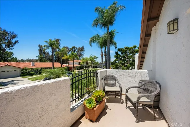a roof deck with table and chairs and potted plants