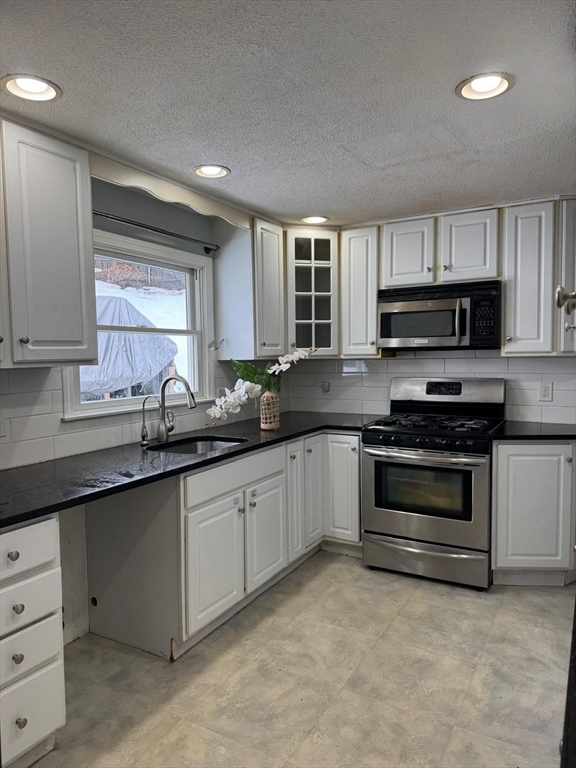 22 Falcon Street Methuen, MA 01844 - Photo 9 of 12 a kitchen with sink a microwave and cabinets