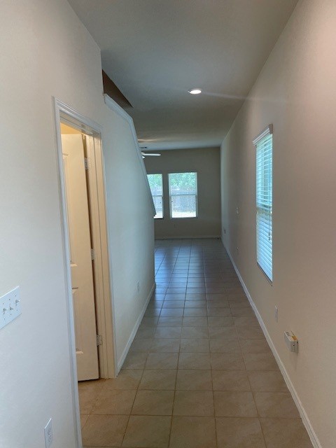 10201 Gertrudis Loop Austin, TX 78747 - Photo 2 of 24 A long entryway with tile flooring leads toward an illuminated living space.