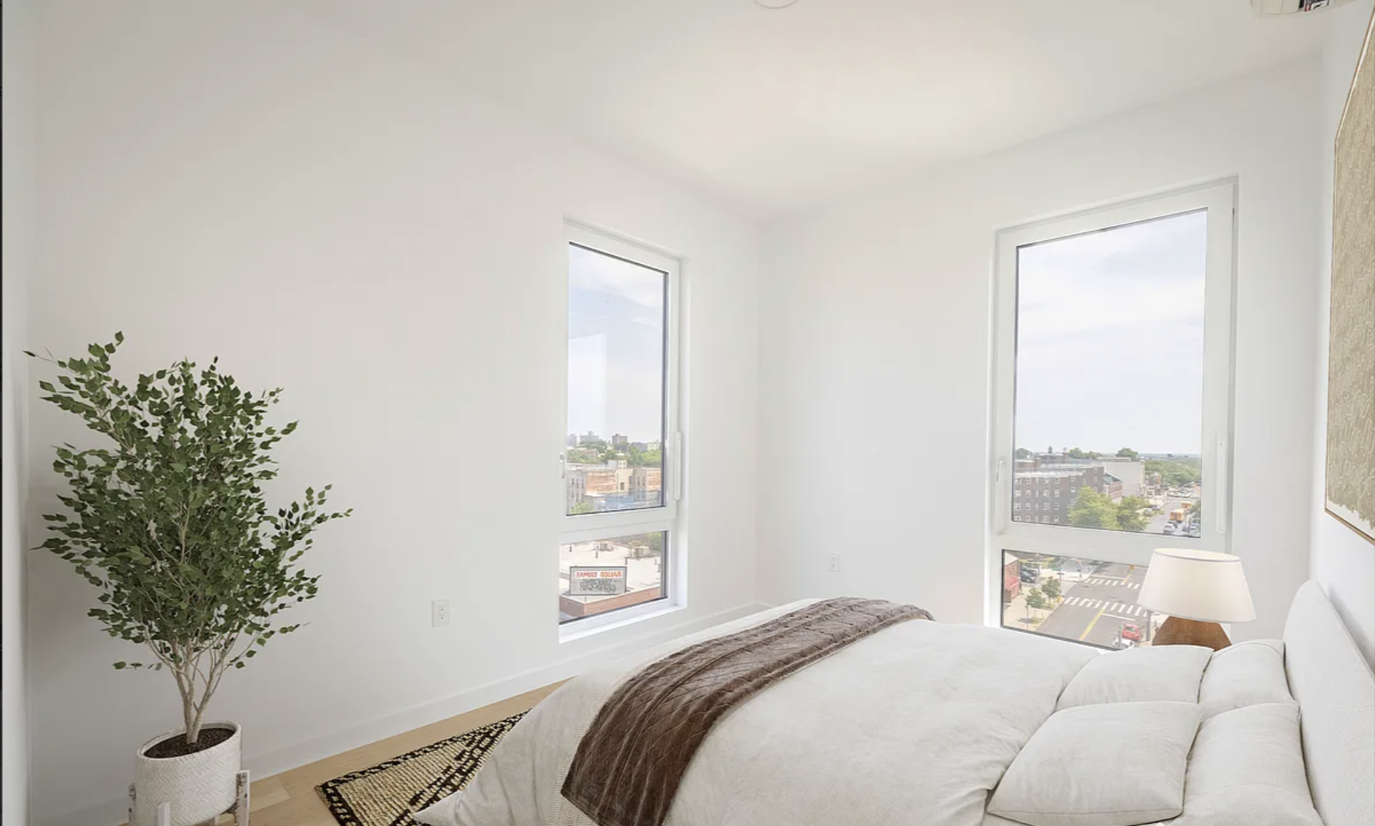 1889 Atlantic Avenue, Unit 9E Brooklyn, NY 11233 - Photo 8 of 9 a bedroom with a bed and a potted plant