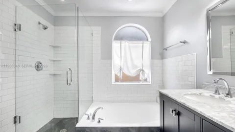 a bathroom with a granite countertop sink a mirror and a bathtub