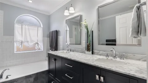 a bathroom with a granite countertop double vanity sink and a mirror