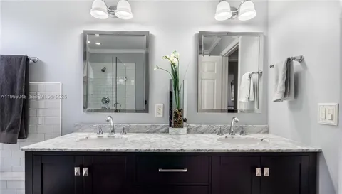 a bathroom with double sink and a mirror