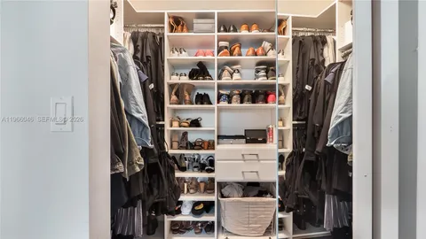 a view of walk in closet with clothes and shoes