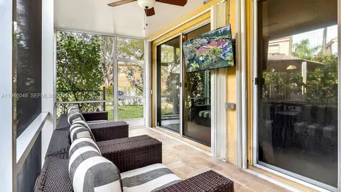 a living room with patio furniture and a floor to ceiling window
