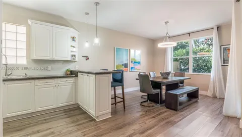 a kitchen with kitchen island granite countertop a sink cabinets and wooden floor