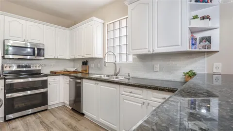 a kitchen with granite countertop a sink and cabinets