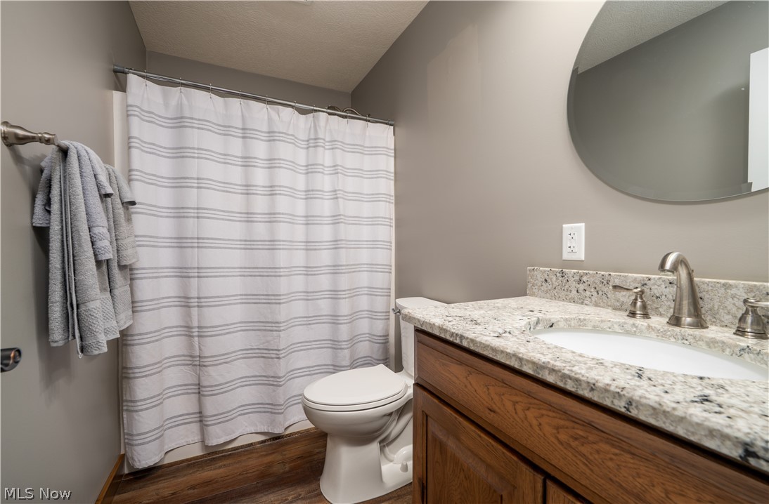 3515 Eastport Road Southeast Dennison, OH 44621 - Photo 17 of 41 Bathroom featuring a wood-finish vanity with a granite-style countertop, undermount sink, and brushed nickel fixtures